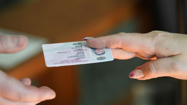 Мужчина получает водительское удостоверение в отделении ГИБДД в Москве