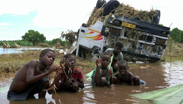 Дети демонстрируют свой улов возле затонувшего корабля, смытого во время тропического шторма Ана на реке Шире в деревне Табва, Малави