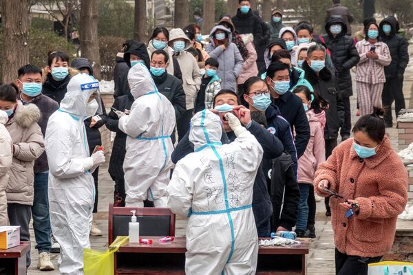 Жители стоят в очереди, чтобы пройти тесты на Covid-19 в Аньяне в центральной китайской провинции Хэнань, Китай