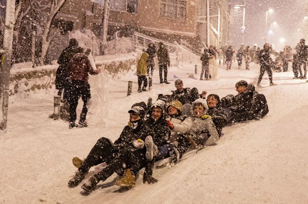 Дети катаются во время снегопада в Стамбуле