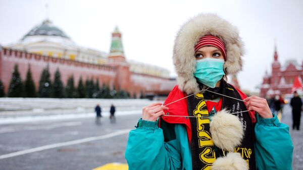 Девушка в защитной маске на Красной Площади в Москве