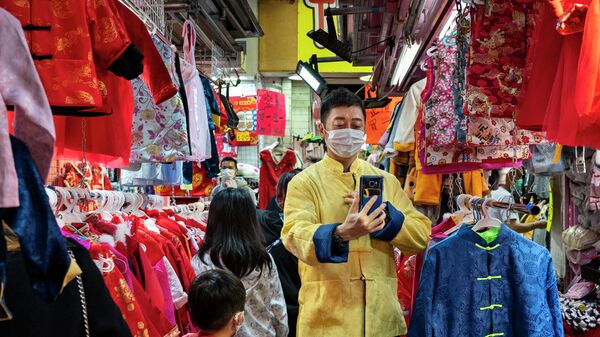 Торговля традиционной китайской новогодней одеждой на уличном рынке во время подготовки к предстоящему Китайскому Новому году в Гонконге