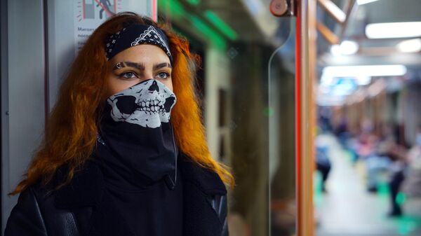 Девушка в маске в вагоне поезда Московского метрополитена