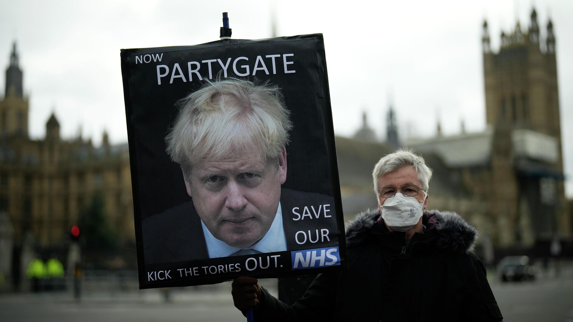 Протестующий с плакатом  с изображением Бориса Джонсона и надписью А теперь partygate около здания Парламента в Лондоне  - РИА Новости, 1920, 23.05.2022