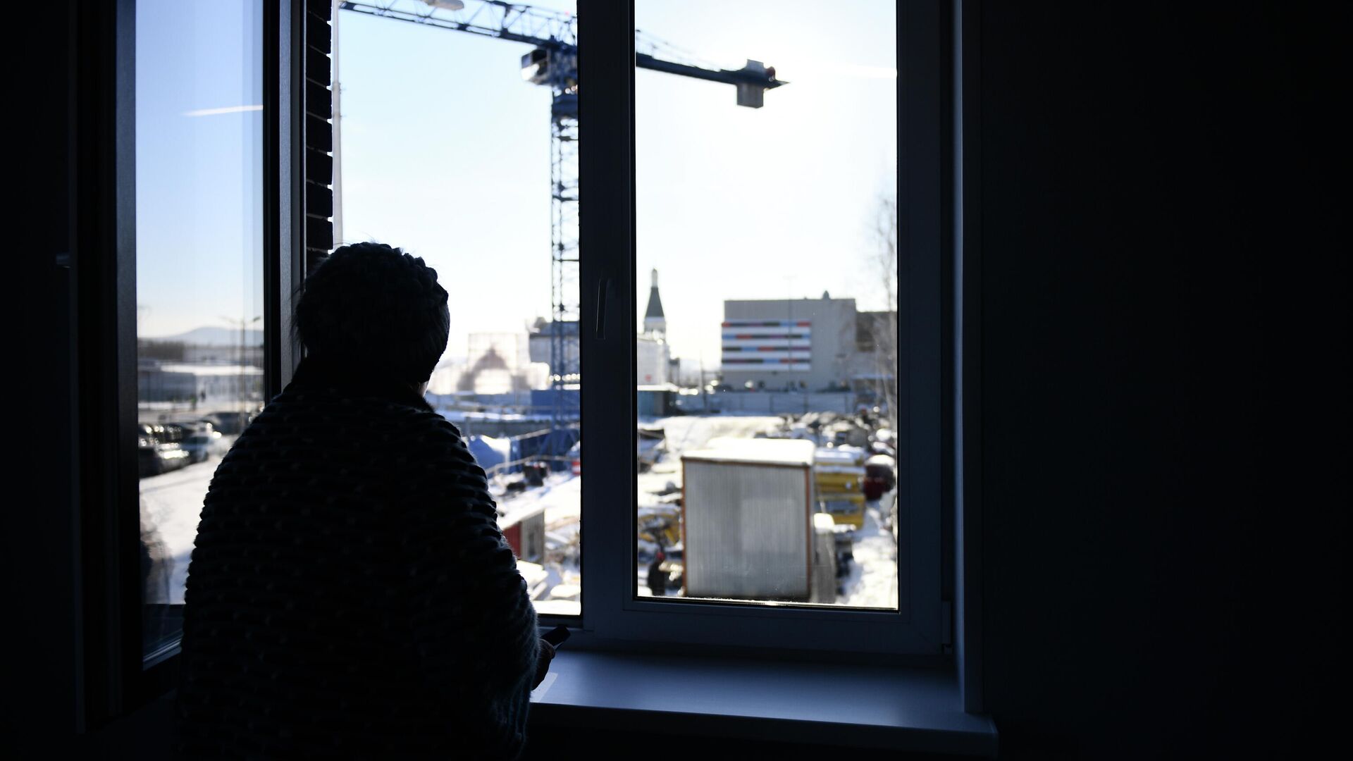 Женщина смотрит из окна своей квартиры Женщина смотрит из окна своей квартиры - РИА Новости, 1920, 04.09.2025