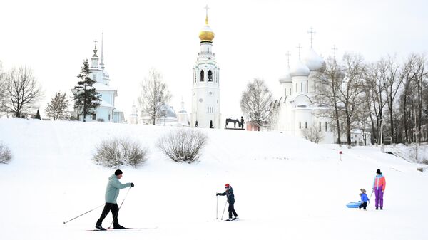 Горожане катаются на лыжах, санках по реке Вологда. На втором плане: купола Софийского собора и колокольня Софийского собора