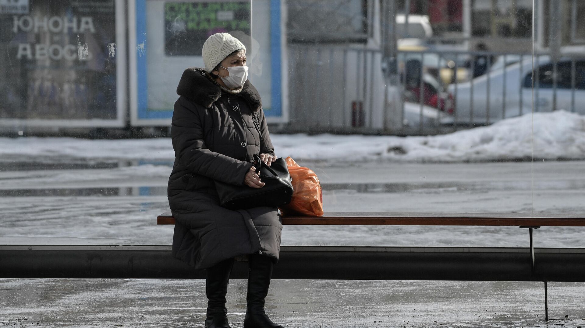 Пожилая женщина в защитной маске на остановке общественного транспорта в Симферополе - РИА Новости, 1920, 06.02.2022