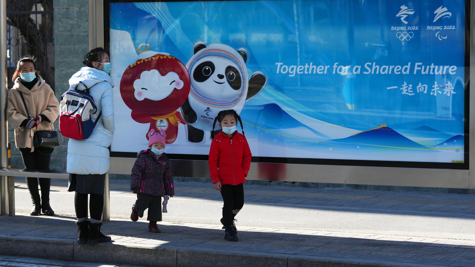 Люди у баннера с изображением официального талисмана зимних Олимпийских игр 2022 - РИА Новости, 1920, 02.02.2022