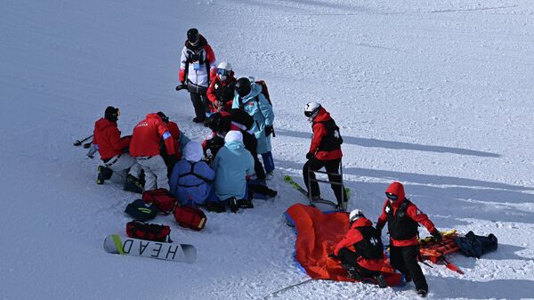 Медперсонал оказывает помощь японской сноубордистке Рине Йошике после падения на Олимпиаде в Пекине