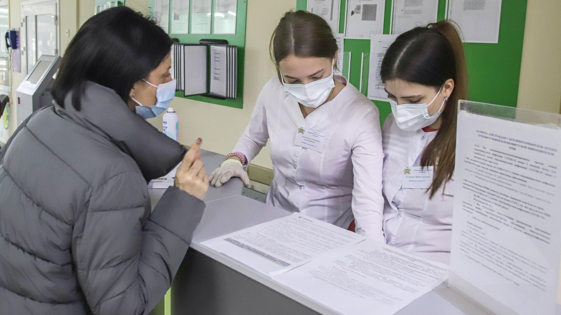 Сотрудницы регистратуры помогают пациентке в поликлинике №1 в Пятигорске - РИА Новости, 1920, 22.02.2022