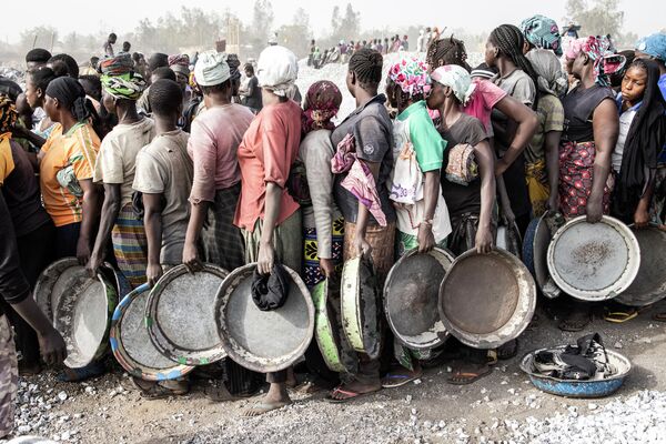 Женщины стоят в очереди, чтобы получить зарплату на гранитной шахте Писси в центре Уагадугу