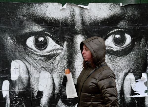 Женщина проходит мимо репродукции портрета Майлза Дэвиса фотографа Ирвина Пенна в Киеве 