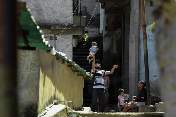 Мужчина подкидывает сына в воздух в Каракасе, Венесуэла