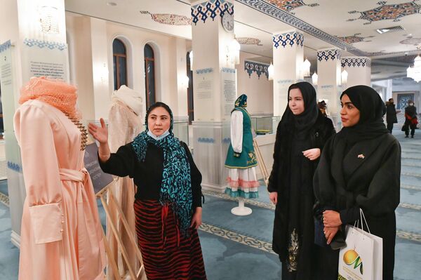 Второй секретарь посольства ОАЭ в РФ, глава отдела культуры и СМИ Наима Альмушаррах рассматривает кумыкский национальный костюм на открытии выставки Хиджаб - моя гордость в Московской соборной мечети