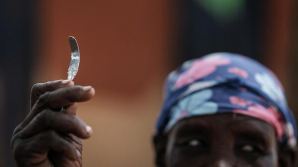 Женщина с самодельным инструментом из гвоздя для проведения операций на женских половых органах на северо-востоке Уганды