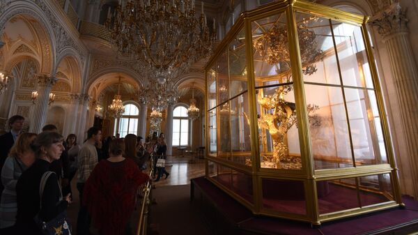 Посетители у часов Павлин в Павильонном зале Государственного Эрмитажа в Санкт-Петербурге