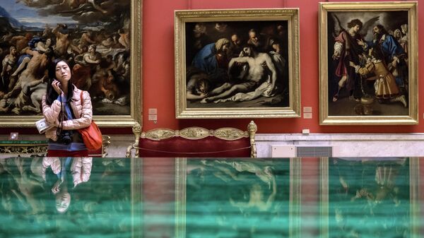 Посетительница рассматривает картины в зале Большой итальянский просвет Государственного Эрмитажа в Санкт-Петербурге