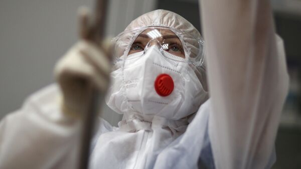 Медицинская сестра готовит капельницы в процедурном кабинете во временном госпитале для пациентов с Covid-19