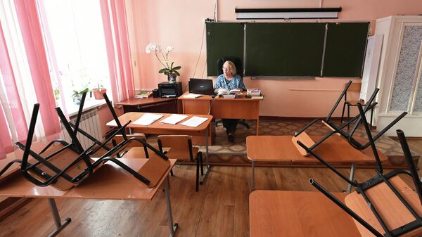 Учитель ведет дистанционный онлайн урок в средней общеобразовательной школе в селе Овсянка Красноярского края