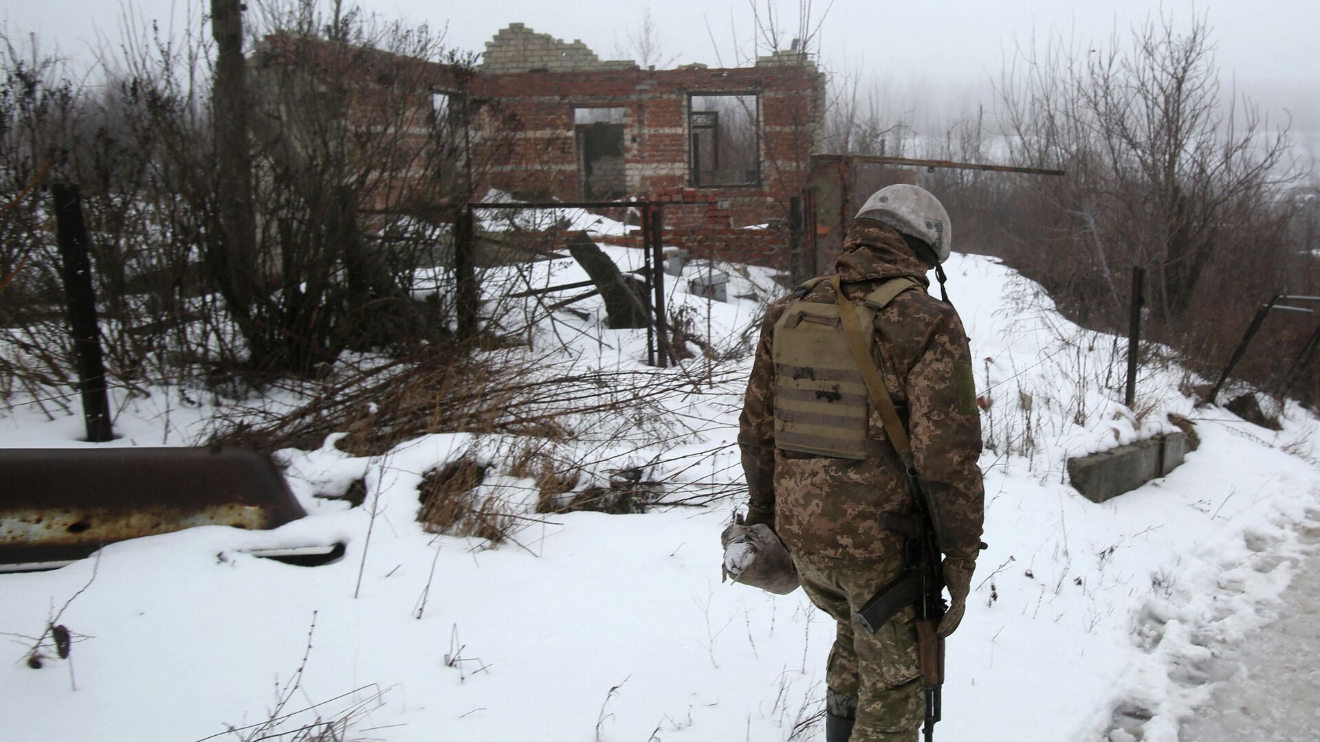 Украинский военнослужащий рядом с разрушенным зданием возле Авдеевки, Донецкая область - РИА Новости, 1920, 05.02.2022