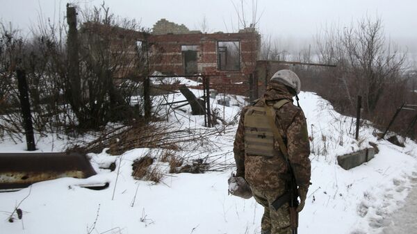Украинский военнослужащий рядом с разрушенным зданием возле Авдеевки, Донецкая область