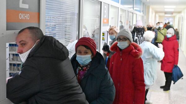 Люди стоят в очереди в поликлинике Омска из-за роста числа заболевших COVID-19