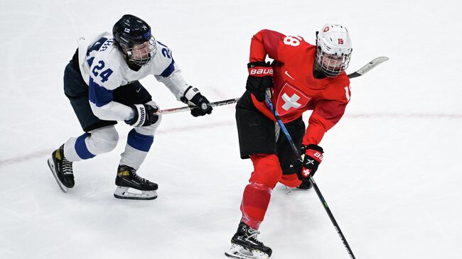 Finland's Viivi Vainikka (L) fights for the puck with Switzerland's Stefanie Wetli during the women's preliminary round group A match of the Beijing 2022 Winter Olympic Games ice hockey competition between Switzerland and Finland, at the National Indoor Stadium in Beijing on February 7, 2022. (Photo by GABRIEL BOUYS / AFP)