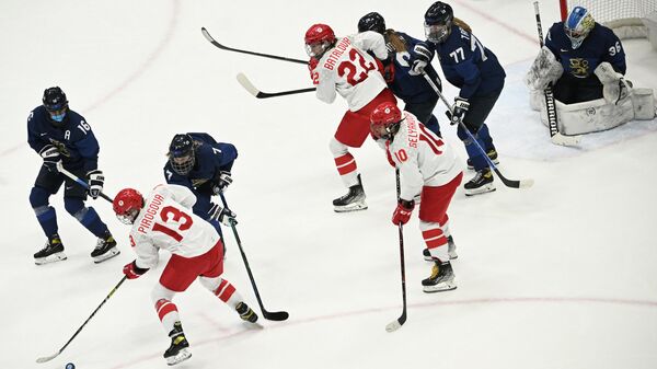 (From L) Finland's Petra Nieminen, Russian Olympic Commitee's Nina Pirogova and Finland's Sanni Rantala go for the puck during the women's preliminary round group A match of the Beijing 2022 Winter Olympic Games ice hockey competition between Finland and players of Russia's Olympic Committee, at the National Indoor Stadium in Beijing on February 8, 2022. (Photo by Anne-Christine POUJOULAT / AFP)