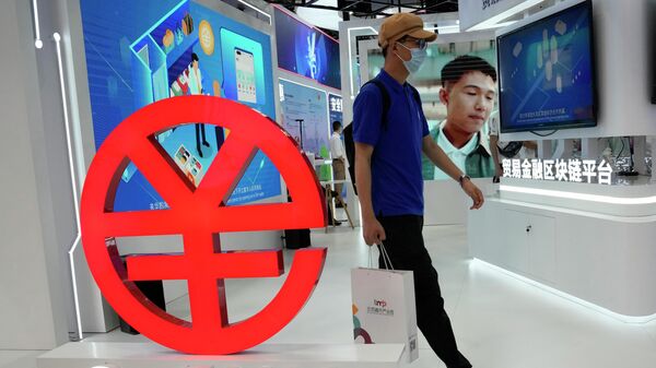 Мужчина проходит мимо логотипа e-CNY, цифровой версии китайского юаня, Пекин, Китай