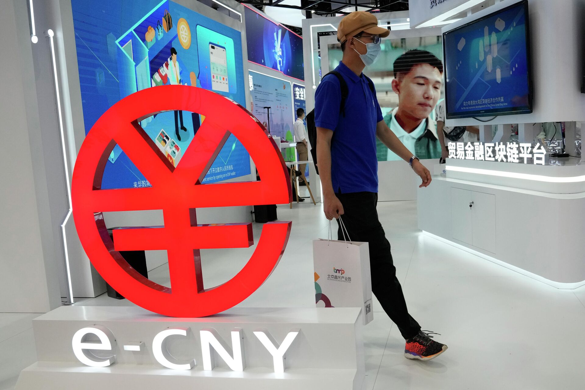 Мужчина проходит мимо логотипа e-CNY, цифровой версии китайского юаня, Пекин, Китай - РИА Новости, 1920, 21.03.2023