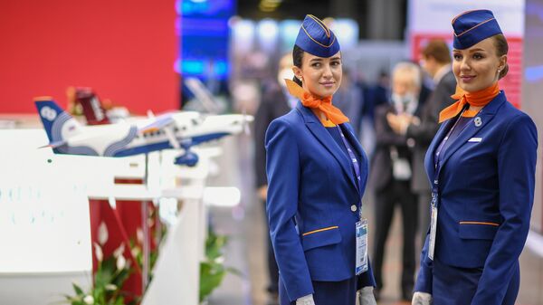 Девушки в форме бортпроводников авиакомпании Aurora на Национальной выставке гражданской авиации NAIS-2022 в Москве