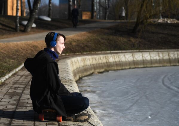 Молодой человек отдыхает в парке Дружбы в Москве
