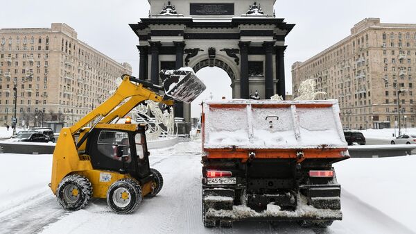 Снегоуборочная техника убирает снег у Триумфальной арки в Москве