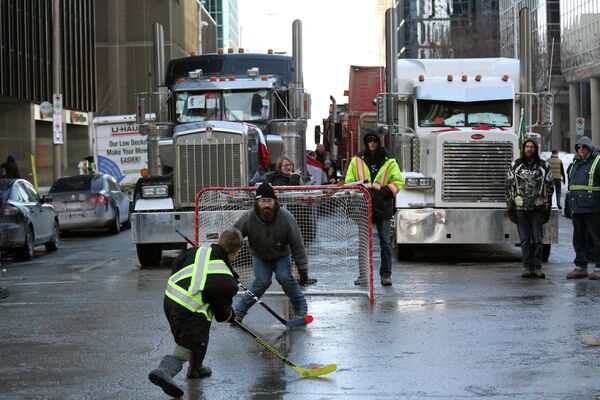 Протестующие играют в уличный хоккей во время протеста против коронавирусных ограничений в Канаде
