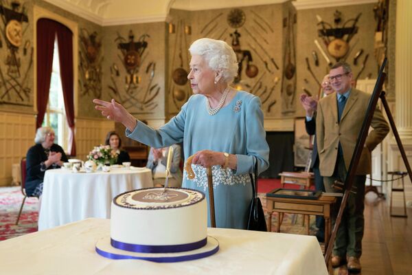 Королева Великобритании Елизавета II разрезает торт во время празднования Платинового юбилея в Сандрингемском дворце, Англия