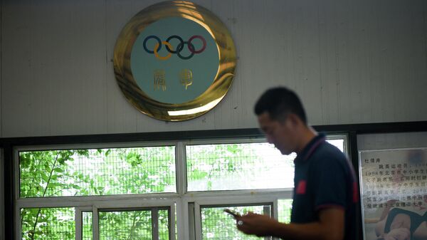 Тренер по горнолыжному спорту на фоне символики Олимпийских игр в Пекине