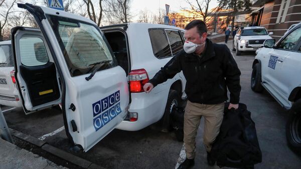 Сотрудник ОБСЕ с багажом возле отеля Park Inn в Донецке, 13 февраля 2022