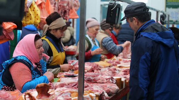 Покупатель выбирает мясо на продовольственном рынке в Киеве