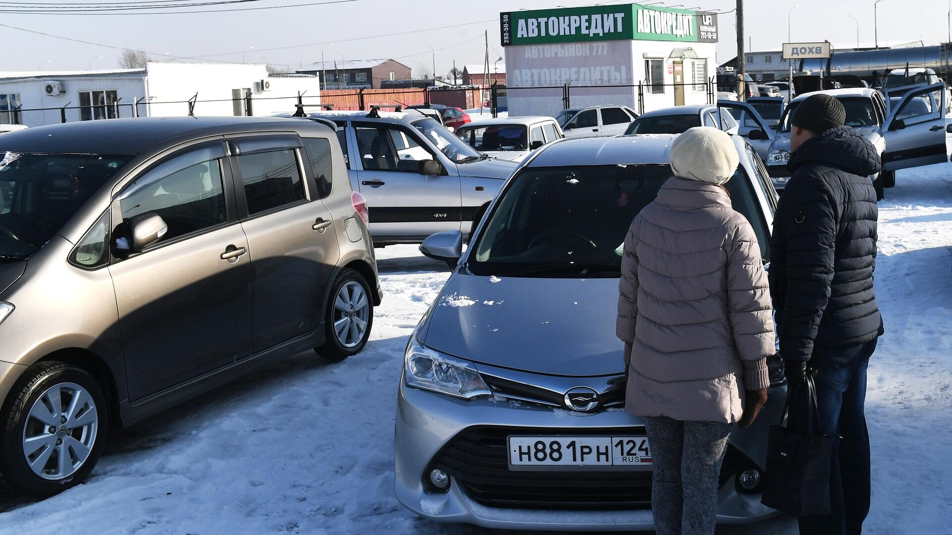 Покупатели у подержанного автомобиля, выставленного на продажу - РИА Новости, 1920, 29.11.2025