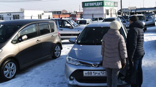 Покупатели у подержанного автомобиля, выставленного на продажу