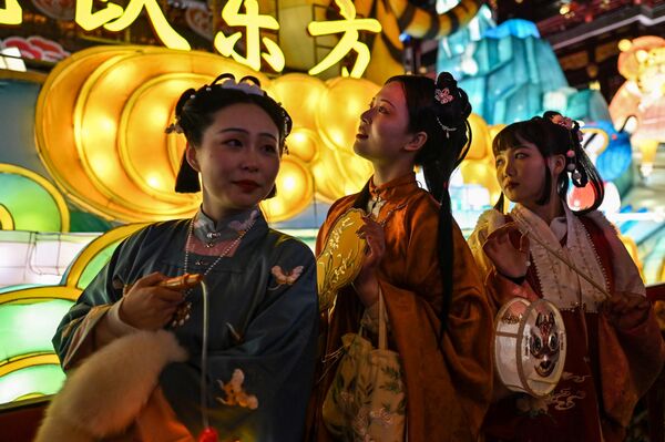 Девушки в традиционных костюмах во время фестиваля фонарей в саду Юйюань, Шанхай