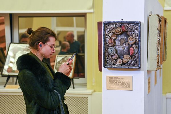 Посетительница проходит рядом с иконой Богоматерь Казанская на выставке Советские православные иконы: исчезающее наследие в Москве