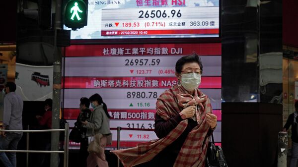 Женщина проходит мимо электронного табло, показывающего индексы акций в Китае