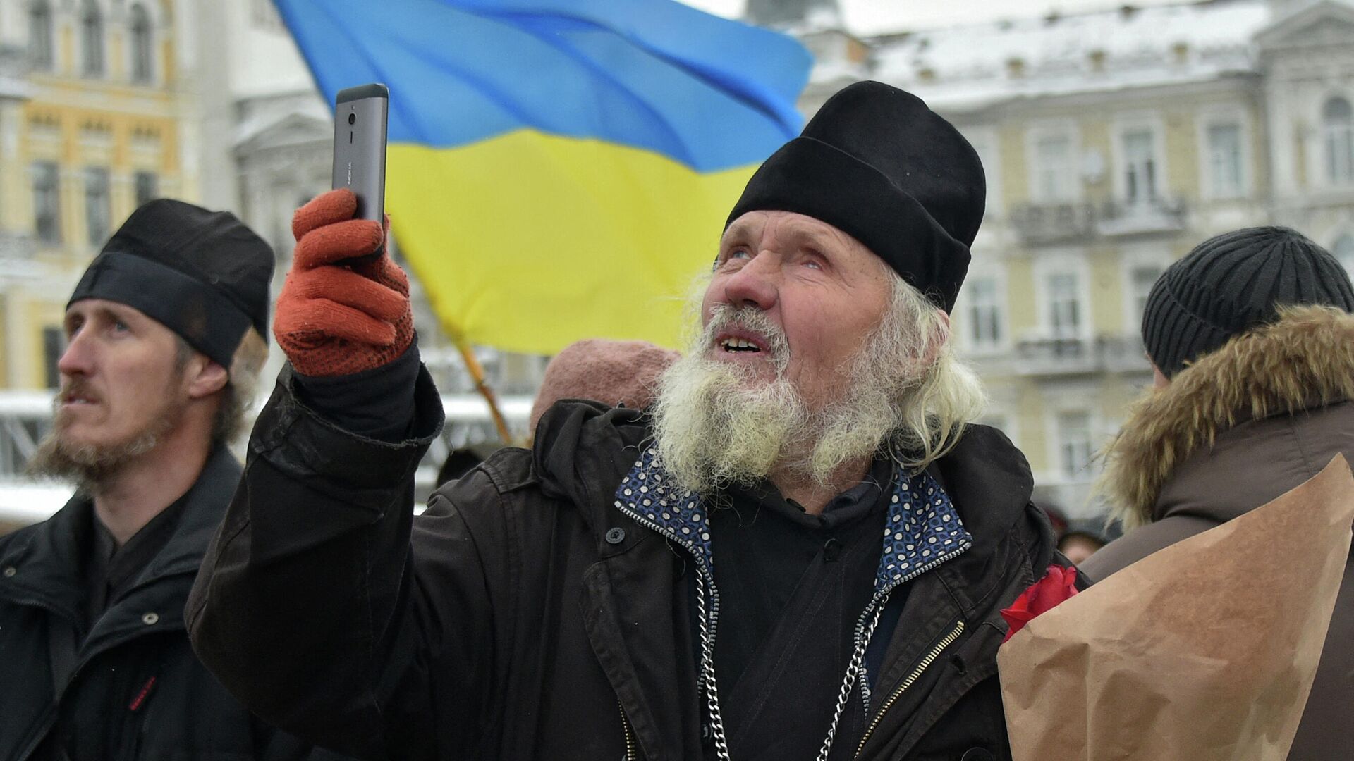 Священник делает фото на телефон на встрече, посвященной созданию независимой церкви в Киеве  - РИА Новости, 1920, 17.02.2022