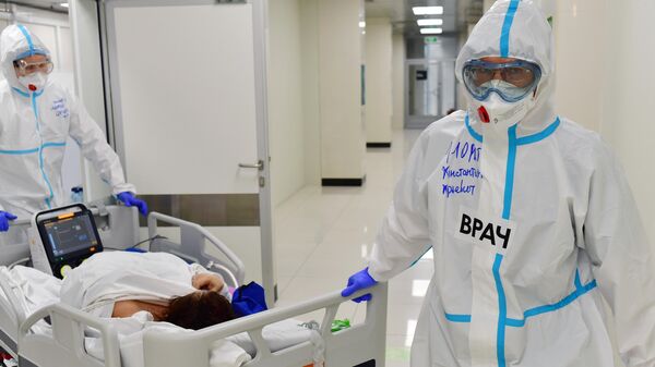 Медицинские работники оказывает помощь пациенту в госпитале для лечения больных коронавирусом