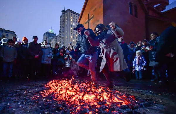 Молодые люди прыгают через костер во время празднования Терендеза у церкви Святого Карапета в Екатеринбурге