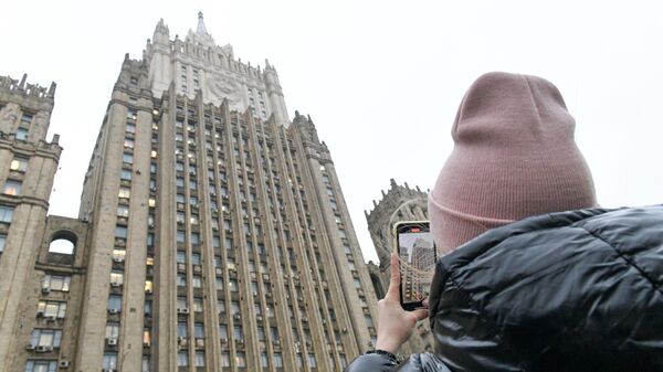 Девушка фотографирует здание Министерства иностранных дел РФ на Смоленской площади в Москве