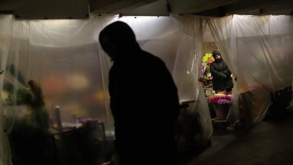 Женщина продает цветы в подземном переходе в центре Киева