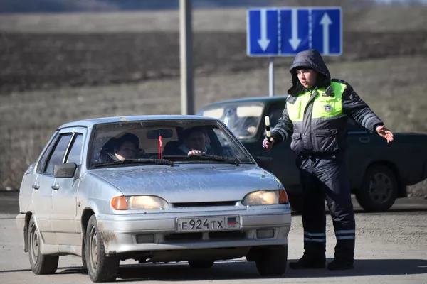 Ένας αξιωματικός επιβολής του νόμου της DPR επικοινωνεί με έναν οδηγό στο σημείο ελέγχου Uspenka στην περιοχή του Ντόνετσκ