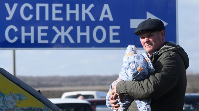 Мужчина с ребенком у контрольно-пропускного пункта Успенка в Донецкой области